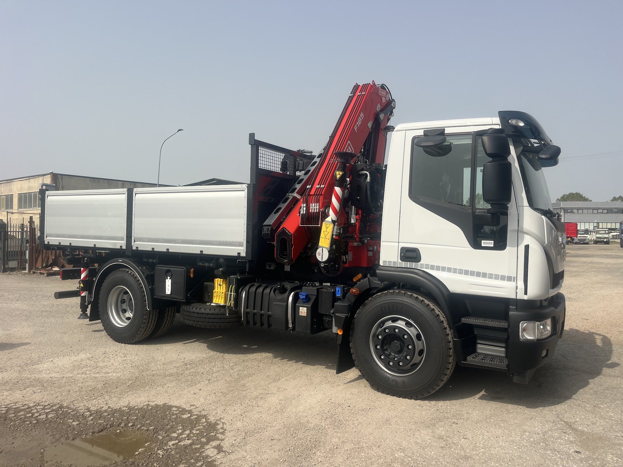 Autocarro bianco Boni con gru rossa ripiegata